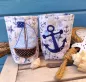 Preview: Stickdatei Set ITH Lichtbeutel mit christlichen Motiven, Foto mit 2 bestickten Ausfertigungen auf maritim gemustertem Stoff. Eine mit Segelboot-Applikation, eine mit Anker-Bestickung.