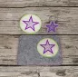 Preview: Stickdatei Set ITH Mug Rugs und Anhänger, Foto zeigt 3 Ausfertigungen. Anhänger in Sternform, fünfzackig, lila auf grauem Filz; Tassenteppich aus grauem Filz mit hellem rundem Abstellplatz, bestickt mit lila Fünfzack-Stern; runder Untersetzter mit ebensol