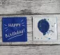 Mobile Preview: Stickdatei Set ITH Geburtstagskarten (10x10 u. 13x18), Foto mit 2 quadratischen Karten auf Holzuntergrund. 1 mal dunkelblau, Schriftzug "HAPPY Birthday", Strahlen/Strich; 1 mal mit transparenter Folie auf hellem luftballonbesticktem Untergrund, dazwischen