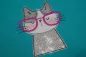 Preview: Stickdatei Set I'm Happy Cat Doodle Applikation inkl. ITH Anhänger, Foto zeigt Ausfertigung auf petrolfarbenem Stoff. Katzenportrait aus grauem, weißem und Glitzer-Stoff, mit rosa-roter Brille.