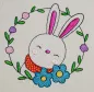 Preview: Osterhase mit floralem Kranz ausgestickt auf Baumwolle.