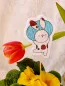 Preview: Stickdatei Set Osterhasen ITH Stabdesigns, Foto mit Designstab, der in Blumentopf mit Blume steckt, im Hintergrund neigt sich eine Tulpe. Auf hellem Filz gestickter Osterhase, ein Osterei hochstemmend.