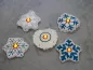 Preview: Stickdatei Set ITH Schneeflocken in 2 Größen, Foto zeigt 5 Schneeflocken, präsentiert auf hellem Untergrund. präsentiert. Zentrum LED-Licht-beleuchtet. Stickornamente divers, hauptsächlich blau-weiß.