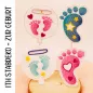 Preview: Stickdatei Set Stabdesigns zur Geburt, Foto mit 4 Designs an Dekostäben, präsentiert auf Holzscheibe, die auf orangem Fell liegt. 2 mal Fuß in blau bzw. rot mit Innenstick Sterne bzw. Herzen. 2 mal Luftballon mit Einstecköse