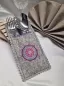 Preview: Stickdatei Set Mandala-Bestecktaschen + Einzelmotive, Foto mit Tasche, befüllt mit Gabel/Messer/Löffel, drapiert auf Tischdecke mit anteilig im Hintergrund sichtbarem Glas, bzw. Serviette. Mittelgrau melierter Filz, der am Rand gebuchtet ist und im obere