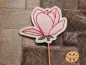 Preview: Freebie Stickdatei ITH Stabdatei Magnolie, Foto einer Ausfertigung am Stab, die auf Pelzuntergrund liegt. Untergrundstoff heller Filz in Blütensilhouette. Blütenkonturen rot, Innenfüllung zarte rosa Bestickung, Stilansatz in braun, 2 kleine Blättchen in g