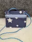 Preview: Stickdatei Set BLANKO ITH Taschen, Foto zeigt Querformat mit hellblauem Reißverschluss frontal an der Oberseite, platziert auf weißem Fell, Hintergrund grau. Außenstoff dunkelblau, mit unterschiedlich großen weißen Sternen bedruckt. Links und rechts oben