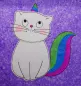Preview: Stickdatei Set KittyCorn Doodle-Applikation inkl. ITH Anhänger, Foto mit Einhorn-Katze, gestickt auf lila meliertem Untergrund. Katze aus hellem Filz, Schwanz und Horn rot-blau-grün gestickt.