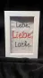 Preview: Stickdatei Set Weil ich Dich liebe! (Für 10x10, 13x18 und 18x30), Foto zeigt weißen Bilderrahmen in Hochkantformat. Darin auf hellem Stoff in diversen Farben aufgestickt Schriftzug: "Lebe, Liebe, Lache.".