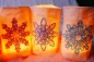Preview: Stickdatei Set ITH Lichtbeutel mit Wintermandalas (13x18 und 16x26), Foto zeigt 3 hell erleuchtete Lichtbeutel aus hellem Stoff mit mandalartiger Blütenbestickung, sternartig, 3 unterschiedliche Garnfarben.