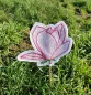 Preview: Freebie Stickdatei ITH Stabdatei Magnolie, Foto einer Ausfertigung, die mit dem Stab in einer grünen Wiese steckt. Motiv: Magnolienblüte mit Stielansatz und zwei grünen Blättchen. Untergrundstoff ist heller Filz in Blütenumriss in roten Konturen mit zarte