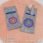 Preview: Stickdatei Set Mandala-Bestecktaschen + Einzelmotive, Foto mit 2 auf orangefarbenem Fell nebeneinander drapierten Bestecktaschen, die rechte mit Gabel und Messer eingesteckt. Mittelgrauer Filz, Hochkantformat, dunkelblau umstickte Einstecköffnung