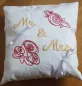 Preview: Stickdatei Set Hochzeit, Foto zeigt quadratisches helles Kissen mit 2 aufgenähten Schleifchen. Bestickung: Rosenköpfe, Schriftzug "Mr. & Mrs." in rot und gelb. Preview: Stickdatei Set Hochzeit, Foto zeigt quadratisches helles Kissen mit 2 aufgenähten Schleifchen. Bestickung: Rosenköpfe, Schriftzug "Mr. & Mrs." in rot und gelb.