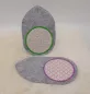 Preview: Stickdatei Set ITH Mug Rug 5, Foto mit einem stehenden und einem liegenden Untersetzer. Diese sind als kreisrundes dick umrandetes Zentrum auf einem hellgrauen Filzuntergrund gestickt, dessen Oval zur einen Seite  spitz ausgezogen ist. Das Zentrum ist auf