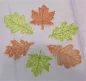 Preview: Stickdatei Set Herbstblätter inkl. ITH Anhänger, Foto mit 6 Blättern auf hellem Untergrund. Gestielte Blätter aus Organza, in orange oder grün, aufgestickte Blattaderstruktur.