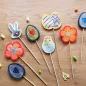 Preview: Ausgestickte Stabdeko mit Hase, Blume, Ei und Küken.