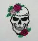 Preview: Totenkopf mit schwarzen Umrandungen und zwei Rosen auf linker Stirn und rechtem Kinn verziehrt