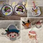 Preview: Stickdatei Set ITH Anhänger Christmas Faces. Fotoquartett zeigt unterschiedliche Anhänger. 4 mal Köpfe: Teddybär, Rehkitz, Schneemann, Junge. 2 mal Weihnachtsbaumkugel, bestickt mit Sternen und Mädchen-, bzw. Jungenkopf.