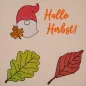 Preview: Stickdatei Set ITH Schilder, Anhänger & Gnom (Herbstkalendertürchen 1 b), Foto zeigt auf hellem Stoff aufgestickte Motive in Herbstfarben. Zwei mal Herbstblatt (Buche und Eiche), einmal Schriftzug "Hallo Herbst!", einmal Gnom mit roter Mütze und Ahornblat