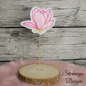 Preview: Freebie Stickdatei ITH Stabdatei Magnolie, Foto einer Ausfertigung, die mit dem Stab in einer Holzscheibe steckt. Stoffuntergrund aus hellem Filz in Blütensilhouette. Blütenzeichnung in rosa-rot mit filigraner rosa Ausstickung. Unterhalb der Blüte Stilans