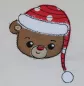 Preview: Stickdatei Set Christmas Faces Doodle-Applikationen. Foto von Applikation Teddybärenkopf mit Mütze, aufgebracht auf hellen Stoff.