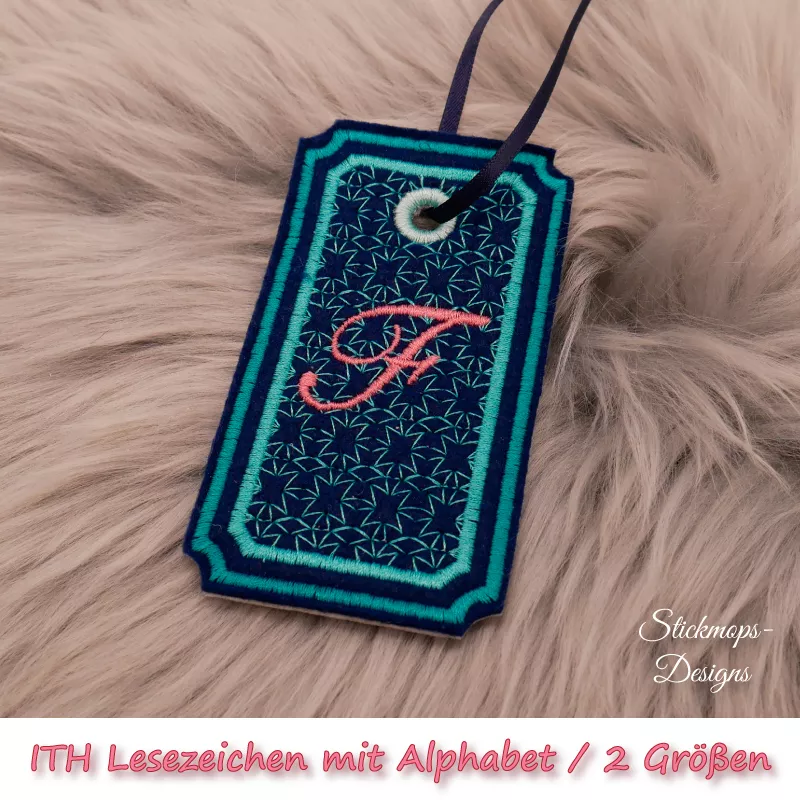 (Osterkalender-Türchen 6A) Stickdatei Set ITH Lesezeichen mit Alphabet in 2 Größen, Foto zeigt am Bändchen garngeöstes Lesezeichen, rechteckig, eingekerbte Ecken. Schwarz, Bestickung türkis, filigranes Muster, in rot schnörkeliger Buchstabe "F".