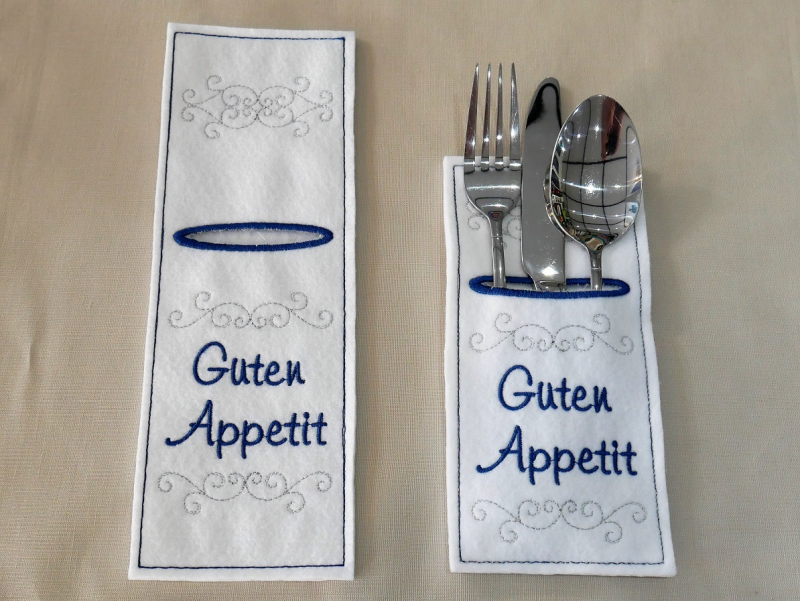 Stickdatei Set ITH Bestecktaschen XXL Set mit insgesamt 70 Dateien. Foto mit 1 kurzen und 1 langen rechteckigen Hochkant-Tasche in weiß, teils gefüllt mit Besteck. Dezente Ziermuster, Schriftzug "Guten Appetit".