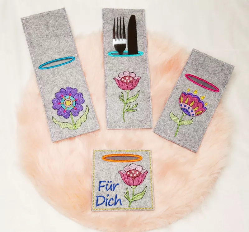Stickdatei Set ITH Bestecktaschen Folksy Flowers (4 Größen), Foto zeigt 4 rechteckige Taschen, mittelgrauer Filz, teilweise mit Besteck befüllt. Unterschiedliche Formate, jeweils Bestickung mit buntem Motiv (diverse Blumen mit Blättern)