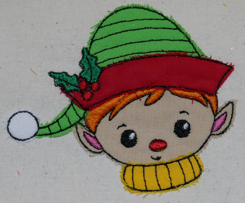 Stickdatei Set Christmas Faces Doodle-Applikationen. Foto von Applikation Jungenkopf mit Mütze, aufgebracht auf hellen Stoff.