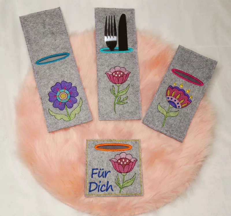 Stickdatei Set ITH Bestecktaschen Folksy Flowers (4 Größen), Foto zeigt 4 rechteckige Taschen, mittelgrauer Filz, teilweise mit Besteck befüllt. Unterschiedliche Formate, jeweils Bestickung mit buntem Motiv (diverse Blumen mit Blättern), einmal zusätzlich