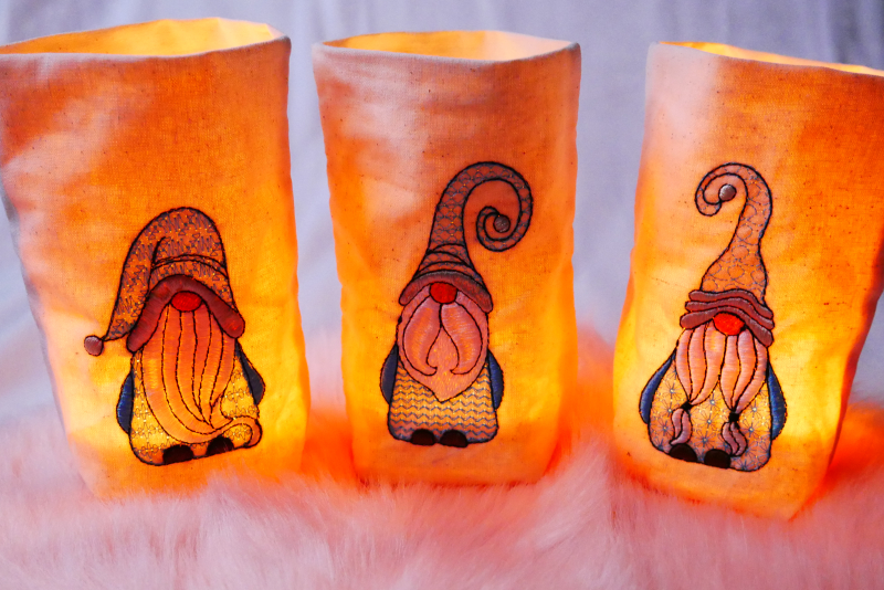 Preview: Stickdatei Set Gnomtrio - drei Gnome in Vollstick mit ITH-Lichtbeutel-Dateien (13x18), Foto mit drei hell erleuchteten Lichtbeuteln, jeder mit einem unterschiedlichen Gnom.
