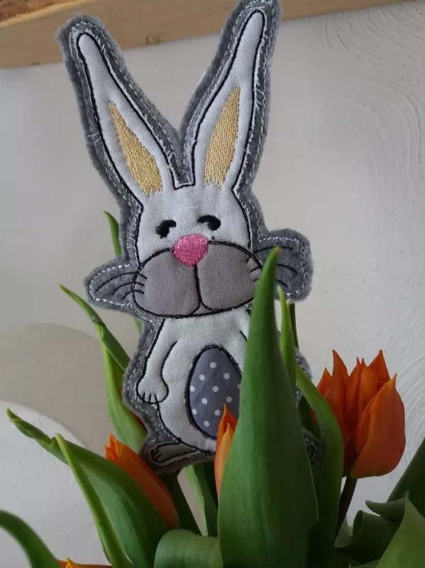 Stickdatei Set ITH-Stecker in Hasen- und Eiform, Foto zeigt Ausfertigung in Tulpenstrauß. Stehender Hase mit blau-getupftem Osterei-Emblem auf dem Bauch.