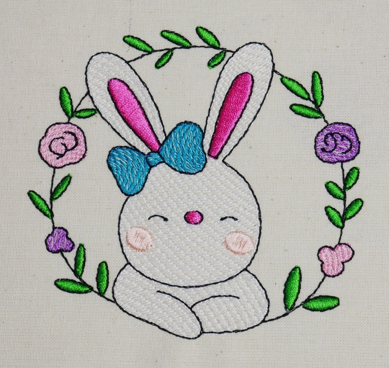 Preview: Osterhase mit floralem Kranz ausgestickt auf Baumwolle.