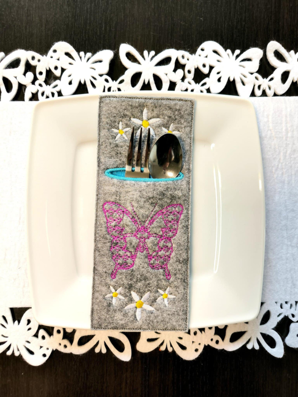 Preview: Stickmotiv Schmetterling auf einer Bestecktasche aufgestickt.