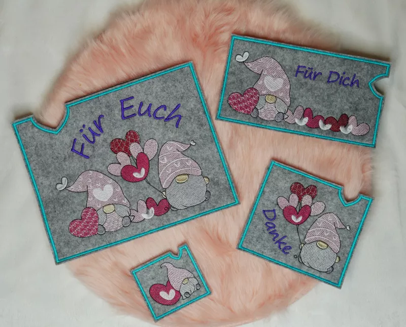 Stickdatei Set Lovegnomes ITH Geschenk- und Schokoladenhüllen, Foto mit 4 Ausfertigungen, zu sehen auf apricotfarbenem Fell. Alle Hüllen rechteckig, grauer Filz, Gnommotive in Variationen, dabei 3 mal mit Schriftzug "Für dich", bzw. "Für euch", bzw. "Dank