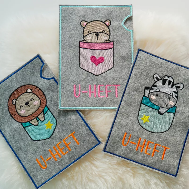 U-Heft-Hüllen mit Zebra, Bärchen und Löwe.