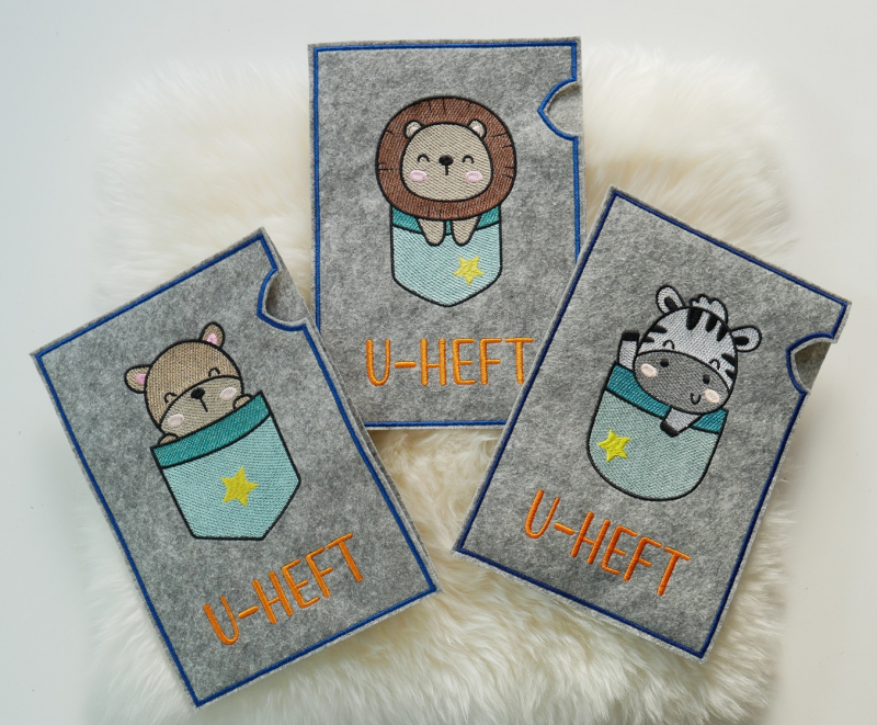 Preview: U-Heft-Hüllen mit Zebra, Löwe und Bärchen in türkis.