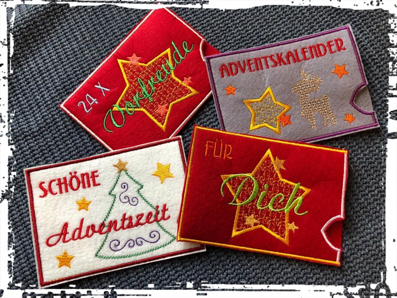 Stickdatei Set ITH Hüllen für Adventskalender to go, Foto mit 2 roten, 1 hellen, 1 grauen querformatigen Filzhülle auf anthrazitfarbenem Untergrund. Bestickung: Rentier, bzw. Stern, bzw. Weihnachtsbaum. Schriftzüge: "24 x Vorfreude", "Adventskalender", "S