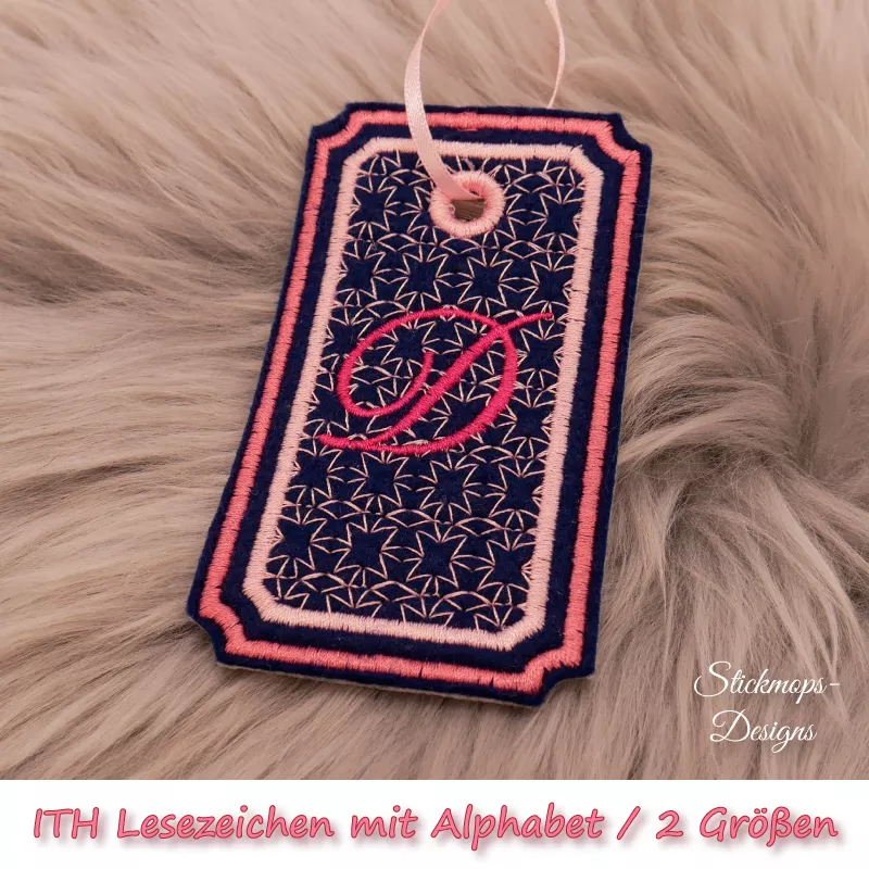 (Osterkalender-Türchen 6A) Stickdatei Set ITH Lesezeichen mit Alphabet in 2 Größen, Foto zeigt am Bändchen garngeöstes Lesezeichen, rechteckig, mit eingekerbten Ecken. Schwarz, Bestickung rosa-apricot, filigranes Muster, in rot schnörkeliger Buchstabe "D"