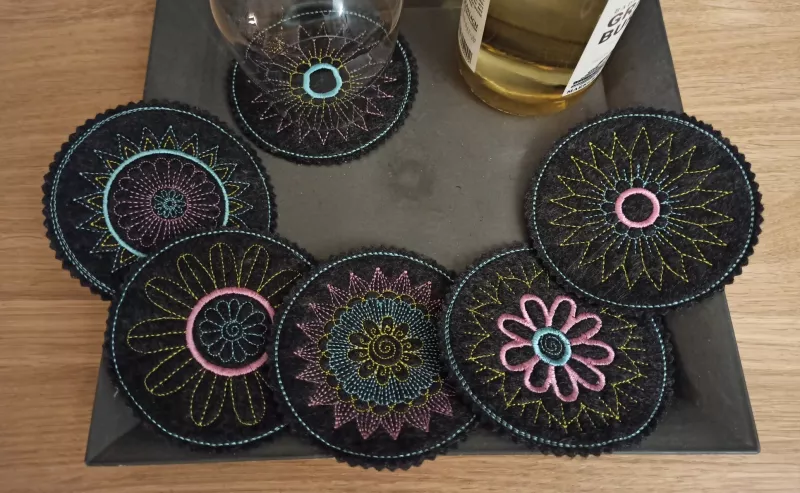 Stickdatei Set Mandala Coaster auf schwarzem Kunstleder gestickt.