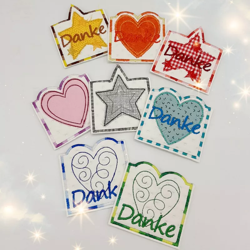 Stickdatei Set ITH Gutschein- und Schokohüllen Danke und Geburtstag, Foto zeigt 8 Hüllen. Jeweils quadratisch mit Stern oder Herz darauf, der obere Hüllenrand ist der Form des Motivrandes angepasst. Teilweise Schriftzug "Danke".