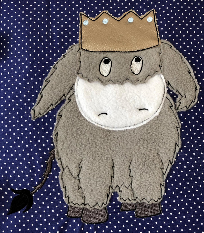 Stickdatei Donkeyking Carlos Doodle Applikation in 5 Größen, Foto zeigt auf Applikation auf lila Untergrund mit weißen Pünktchen. Grau-weißer Esel mit bronzefarbener Krone auf dem Kopf. Stickdatei Donkeyking Carlos Doodle Applikation in 5 Größen, Foto zeigt auf Applikation auf lila Untergrund mit weißen Pünktchen. Grau-weißer Esel mit bronzefarbener Krone auf dem Kopf.