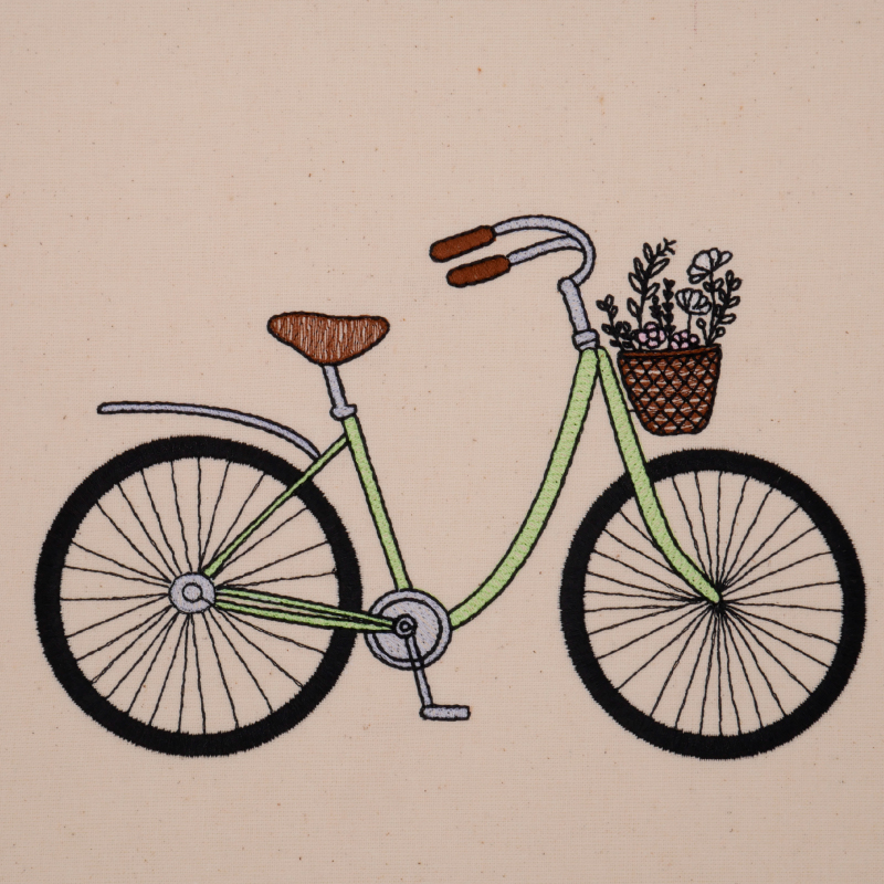 Stickdatei Damenfahrrad in grün gestickt mit Blumen im Fahrradkörbchen. Stickdatei Damenfahrrad in grün gestickt mit Blumen im Fahrradkörbchen.