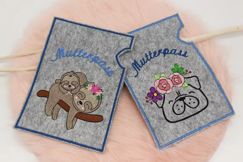 Stickdatei Set ITH Mutterpass-Hüllen für DE und AT + Einzelmotive, Abbildung mit 3 Fotos, auf denen sich je 2 Hüllen befinden. 1 mal Hülle mit Herz mit Blüte und Blättern und Hülle mit Faultieren auf Ast, beide Aufschrift "Mutterpass".