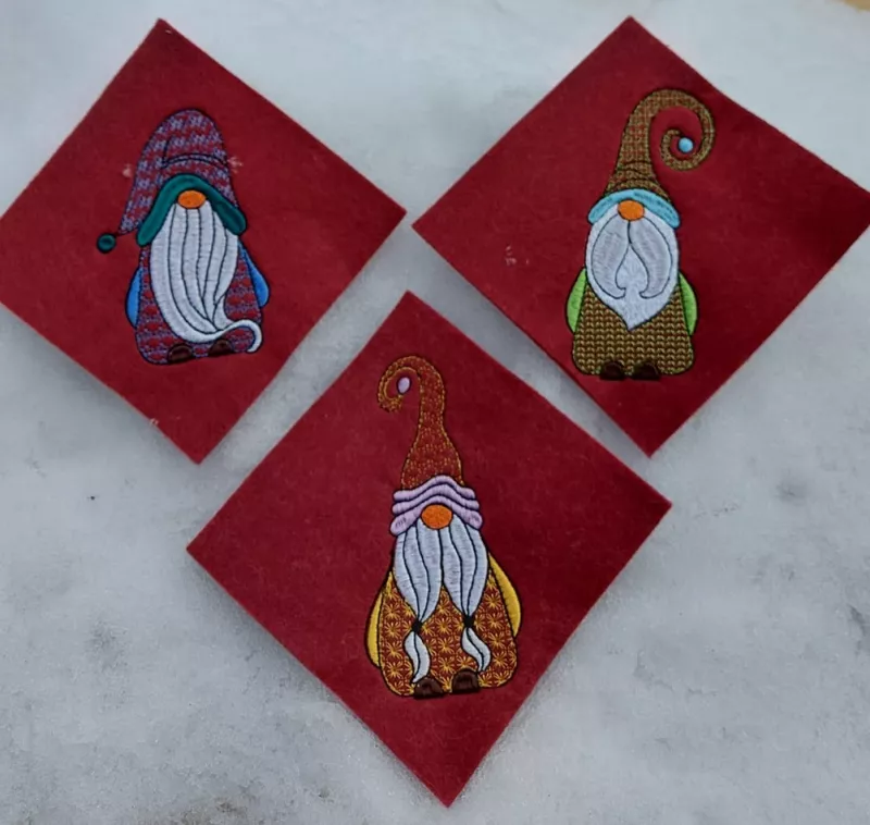 3 Gnome auf Filz ausgestickt.