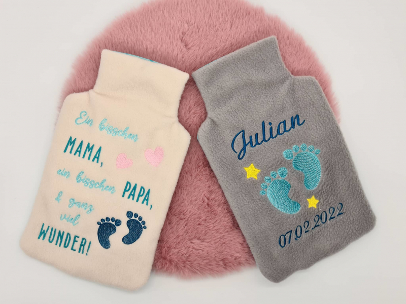 Stickdatei XXL Set ITH Wärmflaschenhüllen mit 24 Designs, Foto zeigt 2 Hüllen aus Flausch-Stoff. Eine hell, Schriftzug "Ein bisschen Mama, ein bisschen Papa und ganz viel Wunder", mit Babyfüßen und Herzchen. Eine mittelbraun-grau, Schriftzug "Julian 07.02 Stickdatei XXL Set ITH Wärmflaschenhüllen mit 24 Designs, Foto zeigt 2 Hüllen aus Flausch-Stoff. Eine hell, Schriftzug "Ein bisschen Mama, ein bisschen Papa und ganz viel Wunder", mit Babyfüßen und Herzchen. Eine mittelbraun-grau, Schriftzug "Julian 07.02