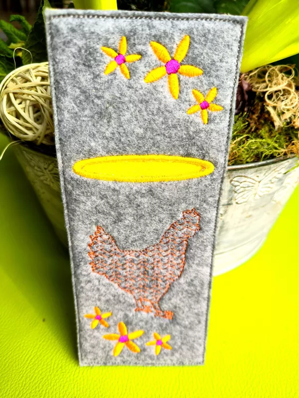 Stickmotiv Huhn auf einer Bestecktasche aufgestickt.