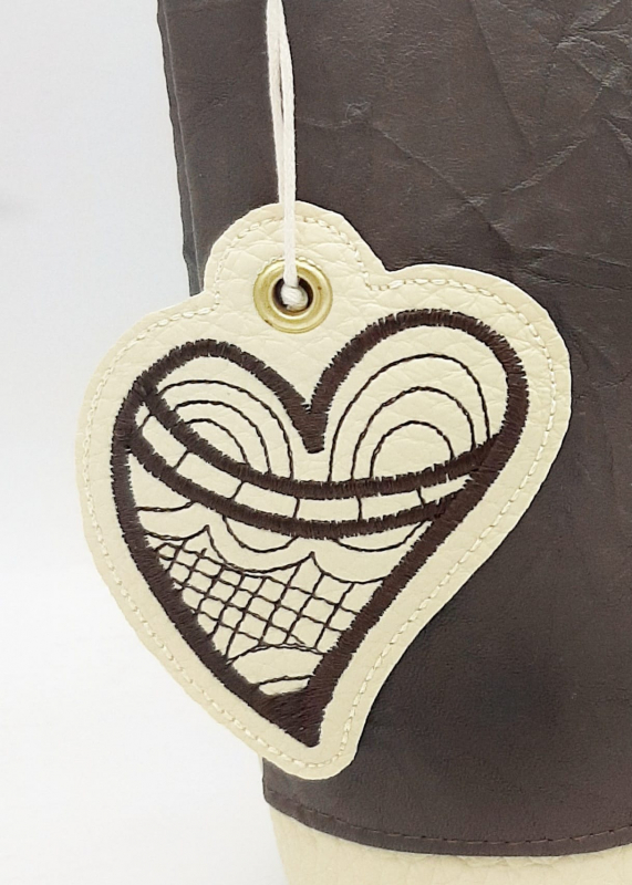 Stickdatei Love inkl. ITH Anhänger Herzen, Foto zeigt einen Herzanhänger, der an einer Kordel hängt, die durch eine Metallöse des Anhängers gezogen ist. Schwarzer filigraner Stick in Herzform auf cremefarbenem Untergrund. Stickdatei Love inkl. ITH Anhänger Herzen, Foto zeigt einen Herzanhänger, der an einer Kordel hängt, die durch eine Metallöse des Anhängers gezogen ist. Schwarzer filigraner Stick in Herzform auf cremefarbenem Untergrund.