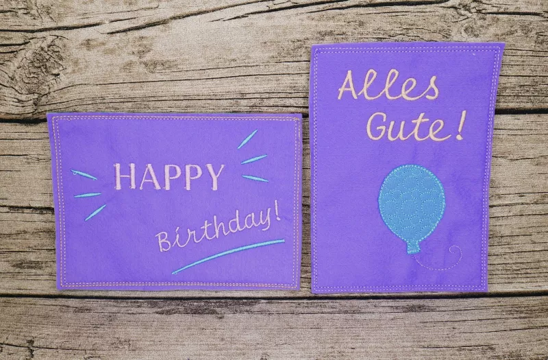 Stickdatei Set ITH Geburtstagskarten (10x10 u. 13x18), Foto mit 2 lila Karten, 1 im Hochkant-, 1 im Querformat. Bestickung: "HAPPY Birthday!"/Strahlen/Strich, bzw. Luftballon mit Schriftzug "Alles Gute!"