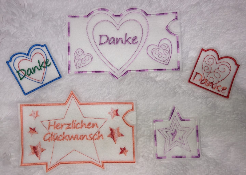 Stickdatei Set ITH Gutschein- und Schokohüllen Danke und Geburtstag, Foto mit 3 quadratischen und 2 querformatigen Hüllen. Jeweils Bestickung Stern oder Herz, der obere Hüllenrand ist der Form des Motivrandes angepasst. Teilweise Schriftzug "Danke".